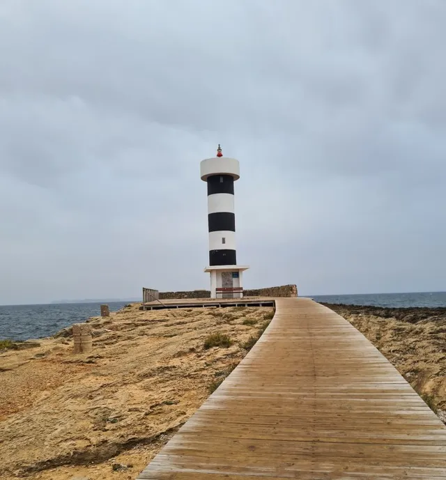 Leuchtturm am Meer mit hölzernem Steg