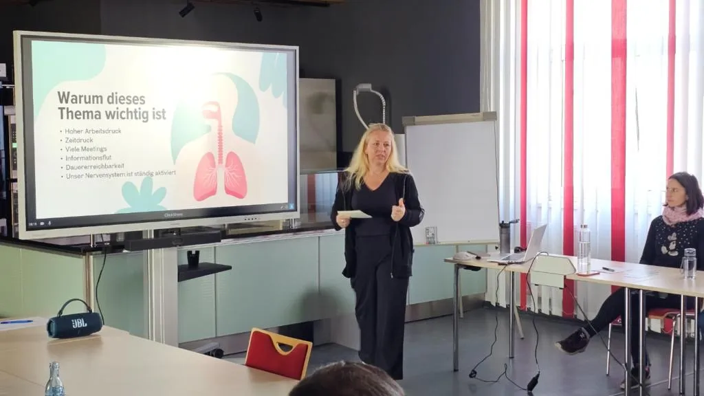 Ines Richter bei einem Atemworkshop vor einem Team in einem Seminarraum